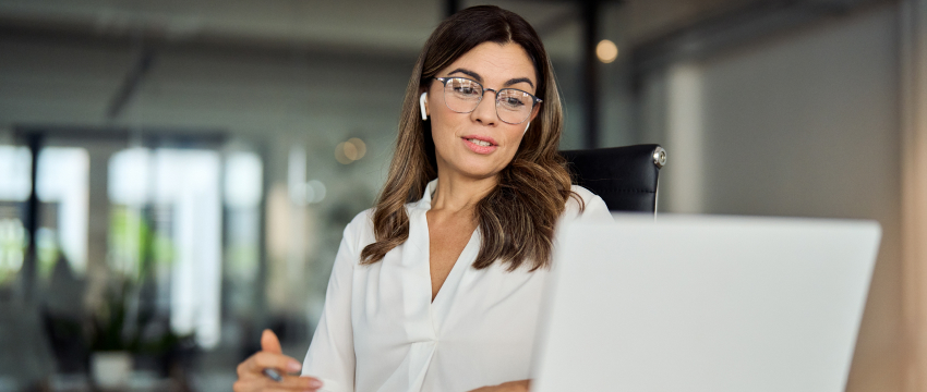 Confident female forex trader analyzing market data on laptop during online trading session